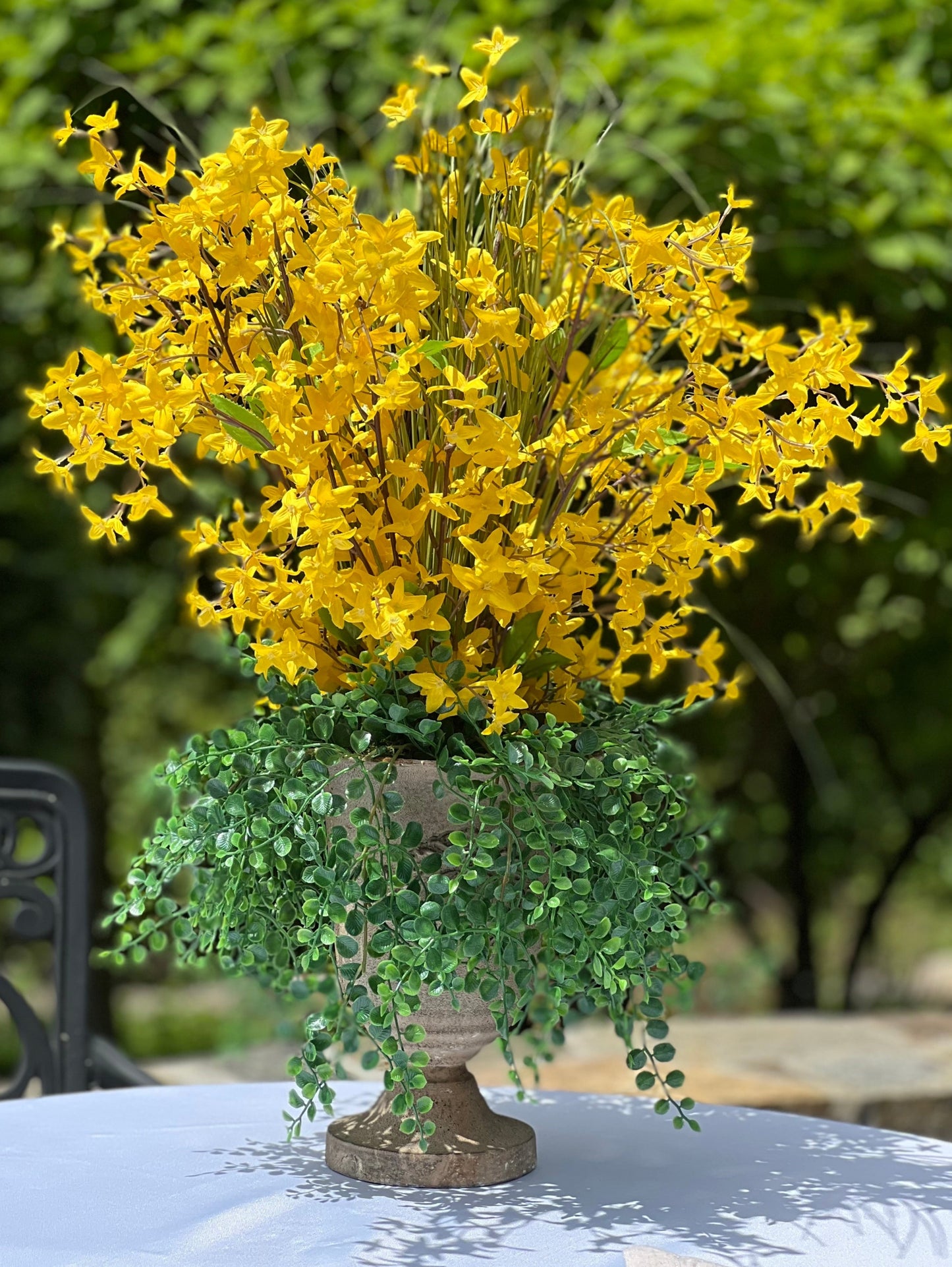 Forsythia amarilla, pastos, exhibición floral de urna alta