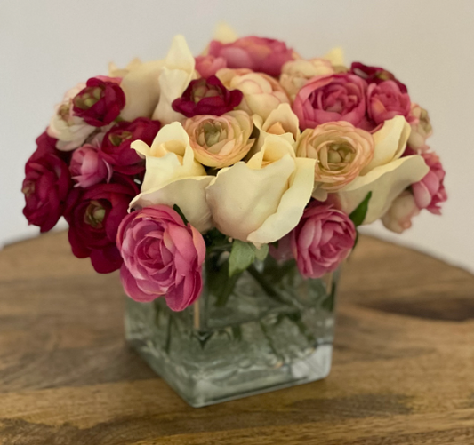 Exhibición floral de ranúnculos y rosas